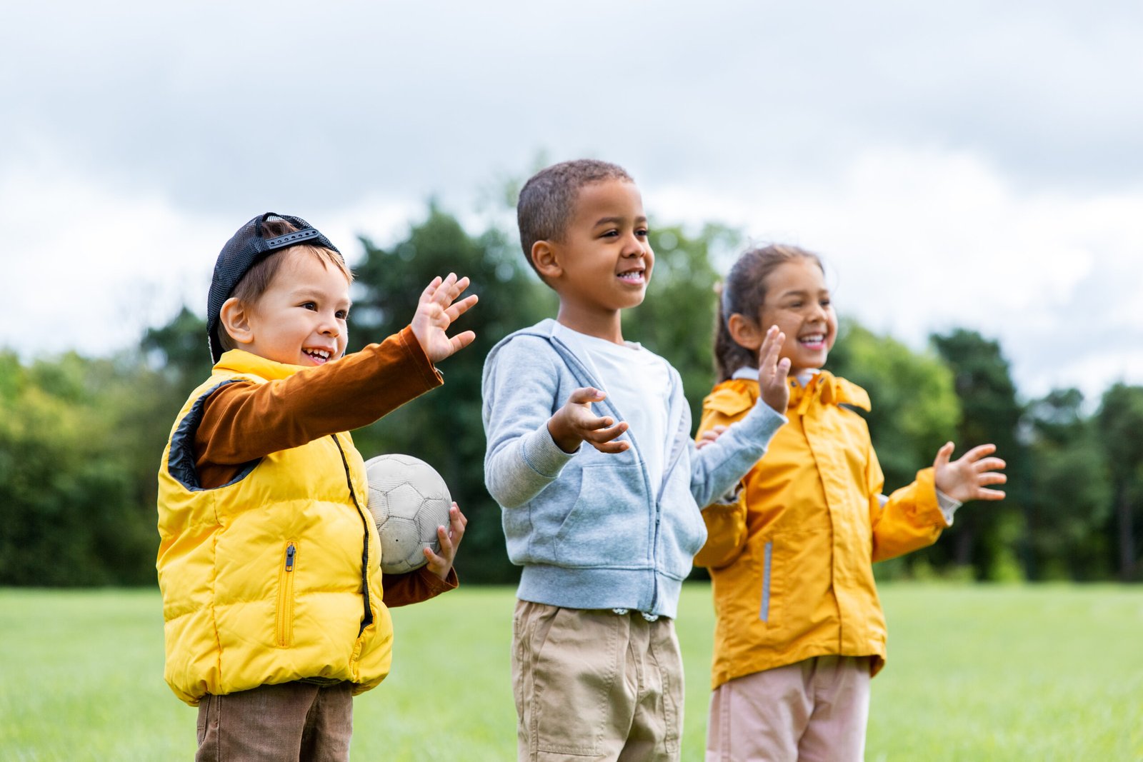 childhood, leisure and people concept - group of happy children with soccer ball at park