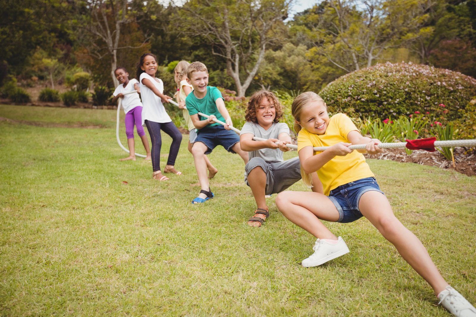 Children pulling a rope in tug of war in the park