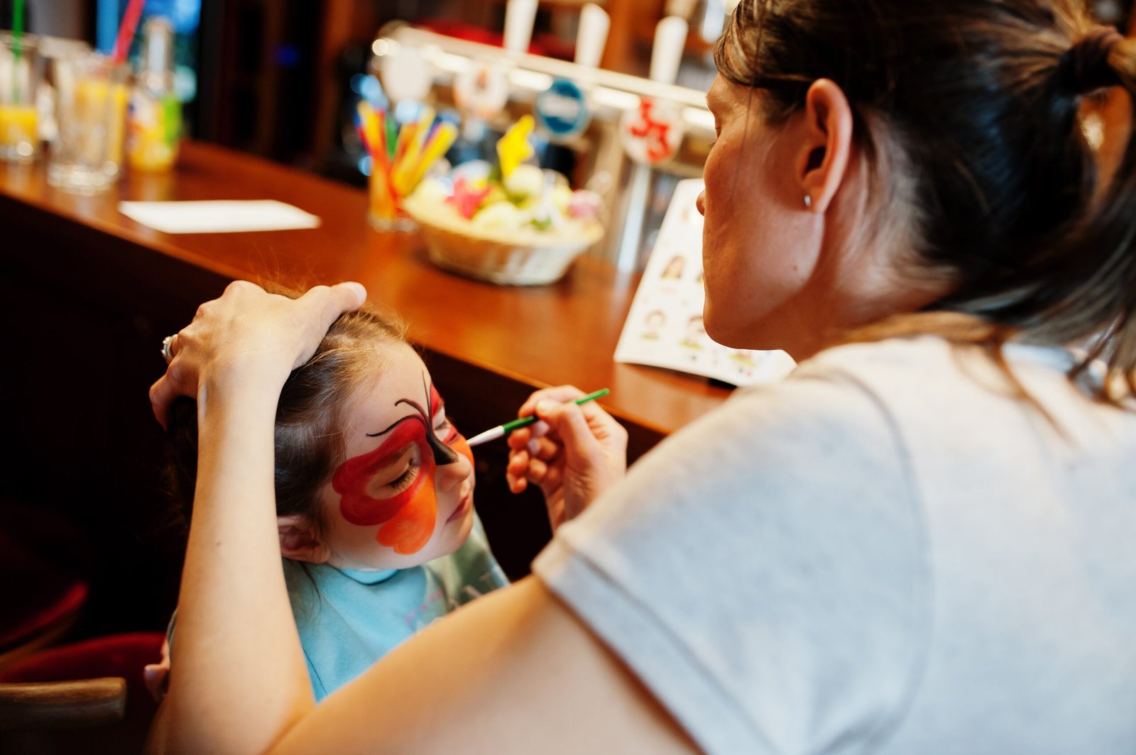 Preparing to Easter concept. Woman doing aqua makeup for baby girl.