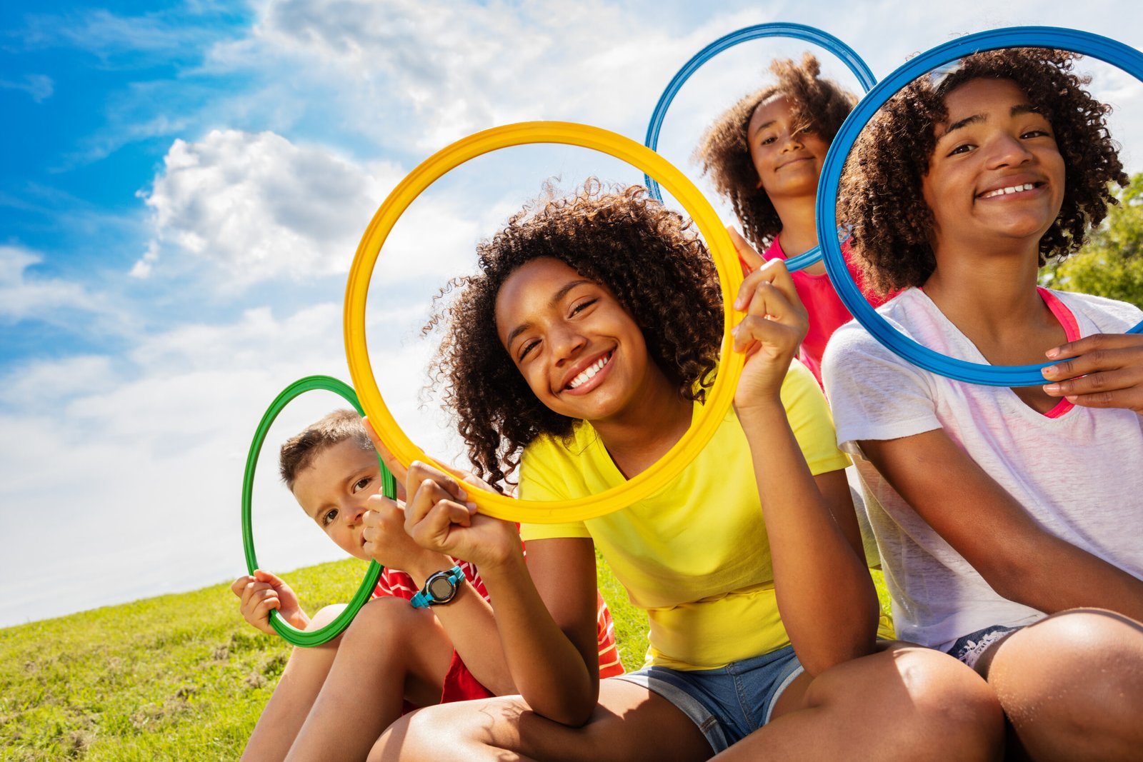 Large group of divers looking children look through color hoops making funny happy portraits